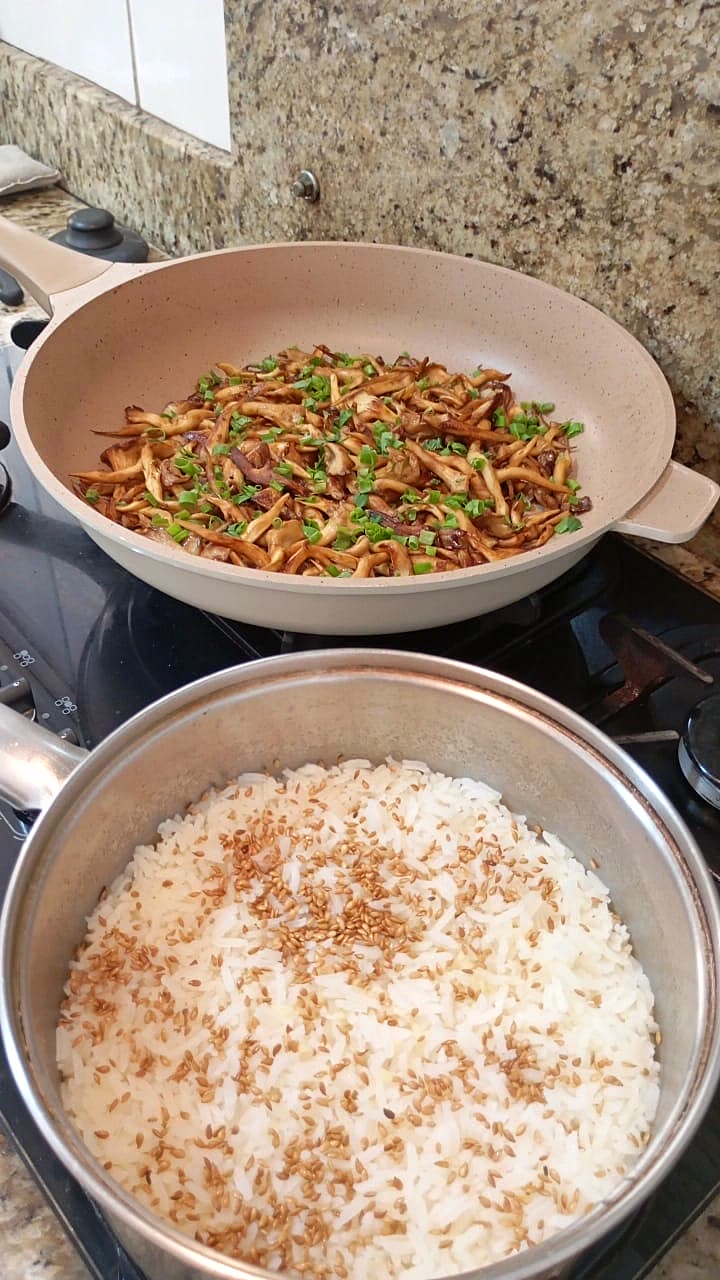 Cogumelos salteados e arroz nas panelas